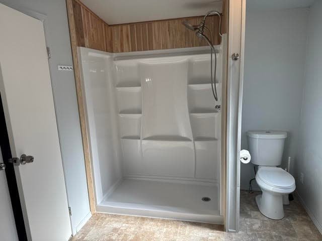 New white walk-in shower stall installed beside a toilet